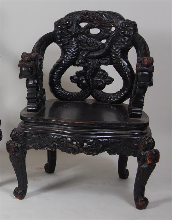 An early 20th century Chinese carved and ebonised hardwood tub chair, the back carved with