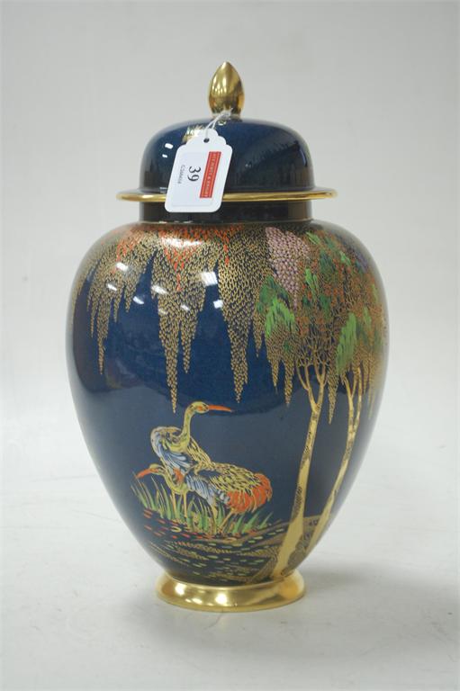A Carltonware vase and cover decorated with exotic birds and trees in gilt and enamels on a powder