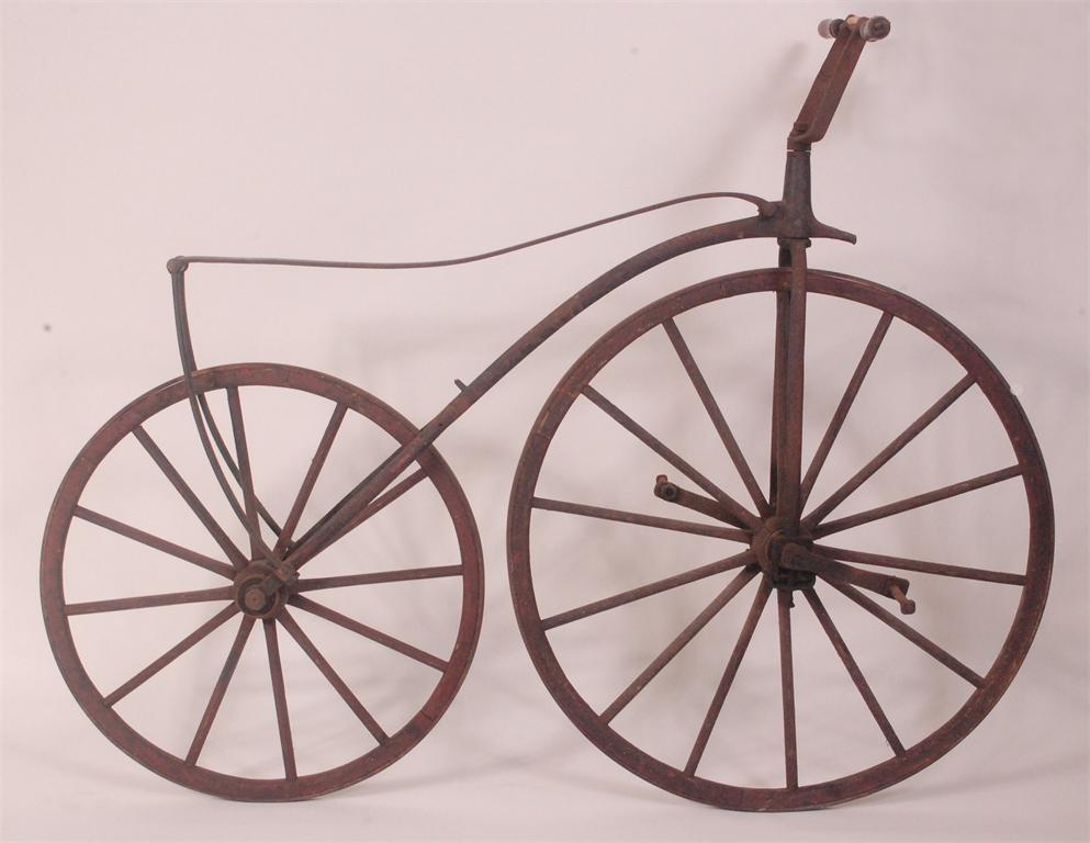 A mid-Victorian 'bone-shaker' or velocipede, circa 1860-1870, having black and red painted wooden