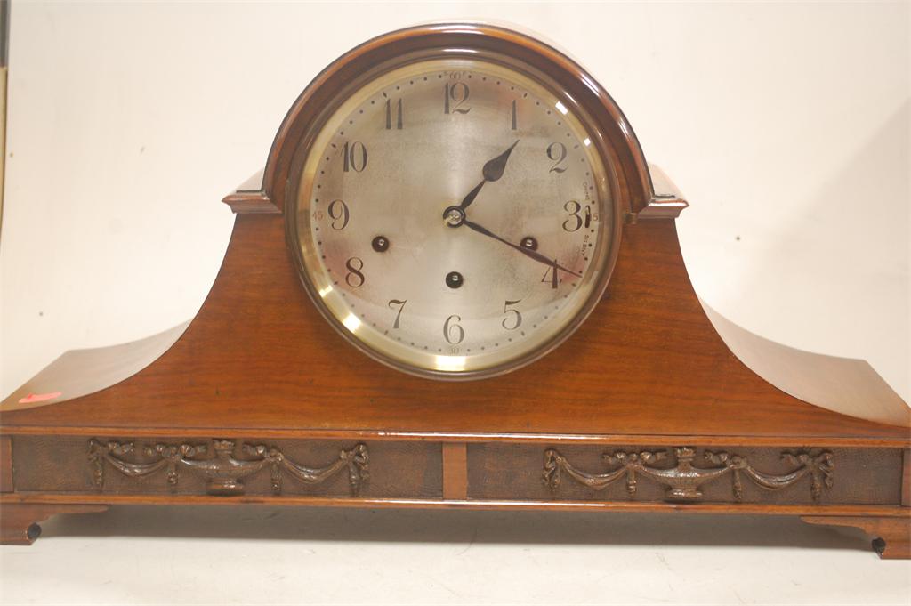 An early 20th century walnut cased dome-top mantel clock, having a silvered dial and eight day going