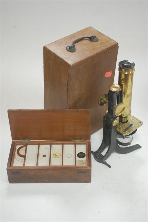 A lacquered brass cased students microscope with cased set of specimen slides (2)