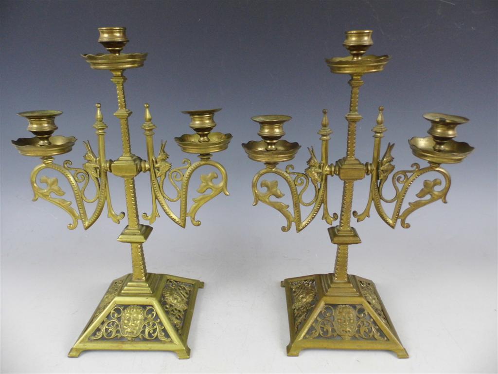 A pair of Victorian Gothic revival brass candelabra, elaborately cast incorporating monsters and