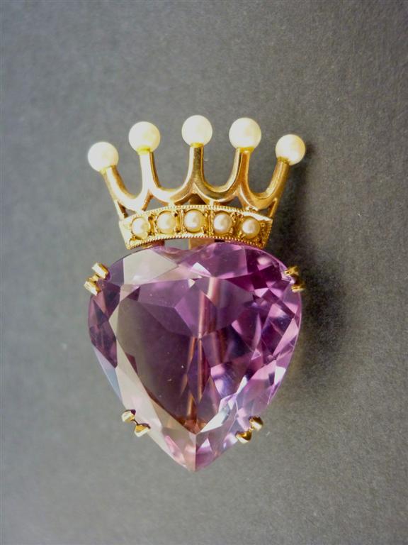 A 9ct gold, amethyst and pearl brooch in the form of a crowned heart, the faceted stone being held