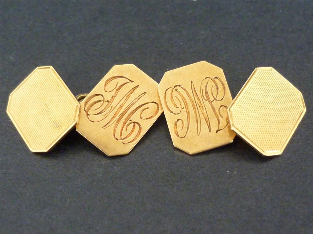 A pair of 18ct gold cufflinks, having canted oblong faces with engine turning and engraved