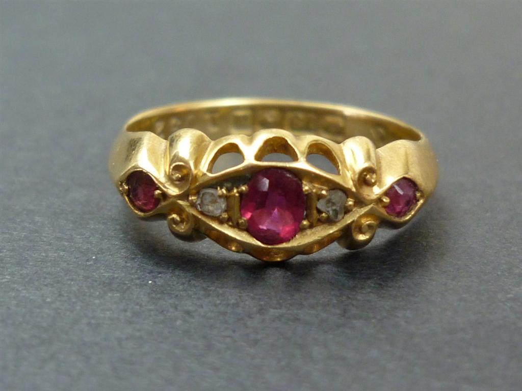 An Edwardian ruby and diamond ring, comprising an oval ruby set between two small rose cut diamonds