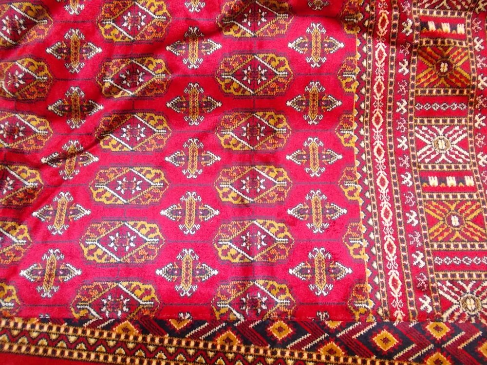 Modern machine woven Bokhara style carpet on red ground 2.3m x 1.6m