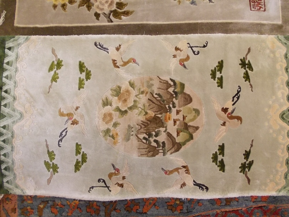 Two small 20th Century Chinese silk wall hanging rugs with bird and floral decoration