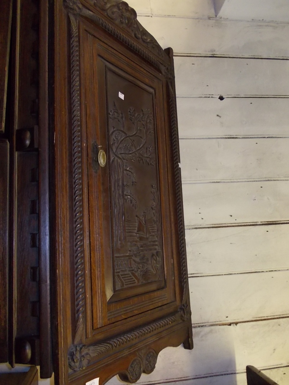 Early 20th Century mahogany hanging corner cabinet with ornate carved panel door