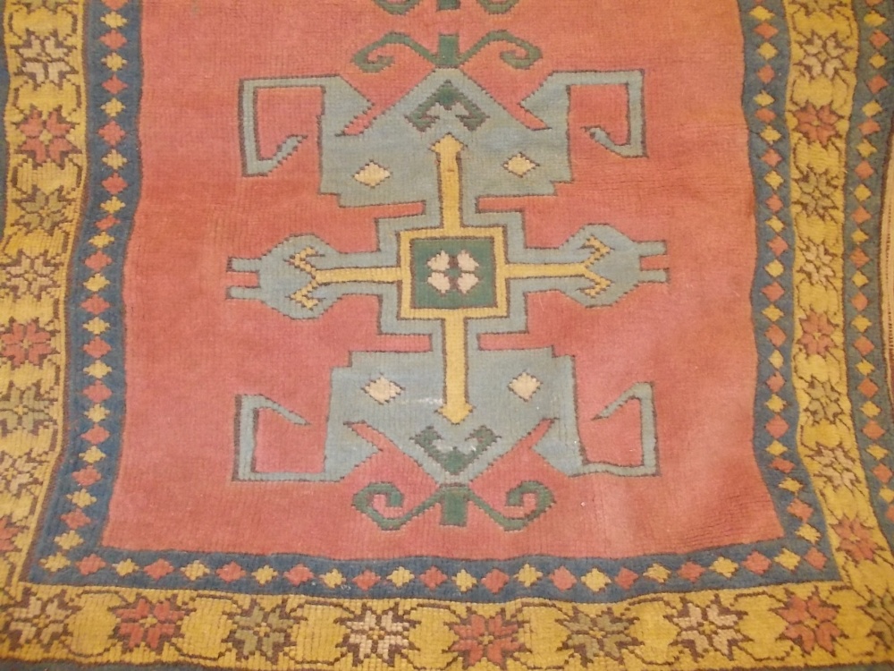 Small 20th Century Turkish Caucasian design rug with twin medallion on a pink ground, 165cms x