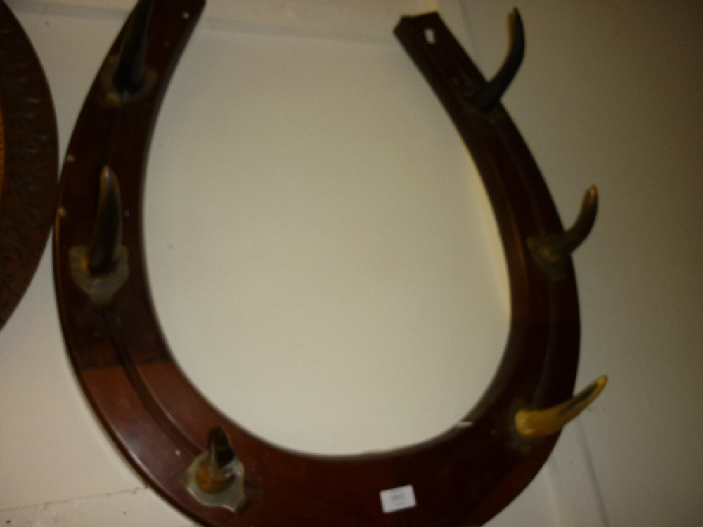 Unusual late 19th or early 20th Century mahogany hat and coat rack of horse shoe form, the hooks