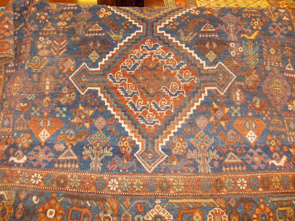 Shiraz rug with triple pole medallion on a blue ground with subsidiary floral designs and borders (