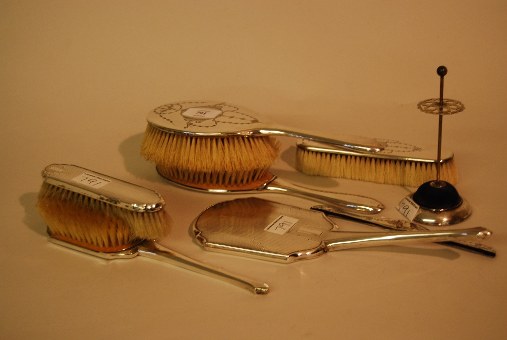 Silver and floral engraved four piece dressing table set and a three piece engine turned silver