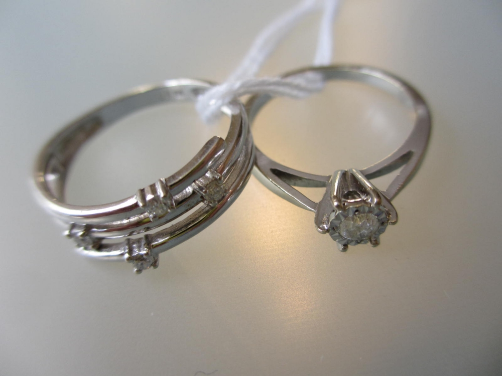 Modern white gold diamond set ring together with another white gold diamond solitaire ring