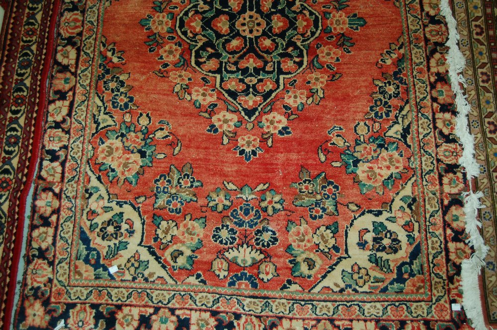 20th Century Sarouk style rug with medallion and floral design on a rose pink ground with borders,