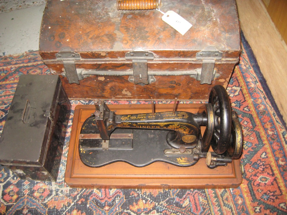 Faux wood painted tin trunk housing a Singer sewing machine