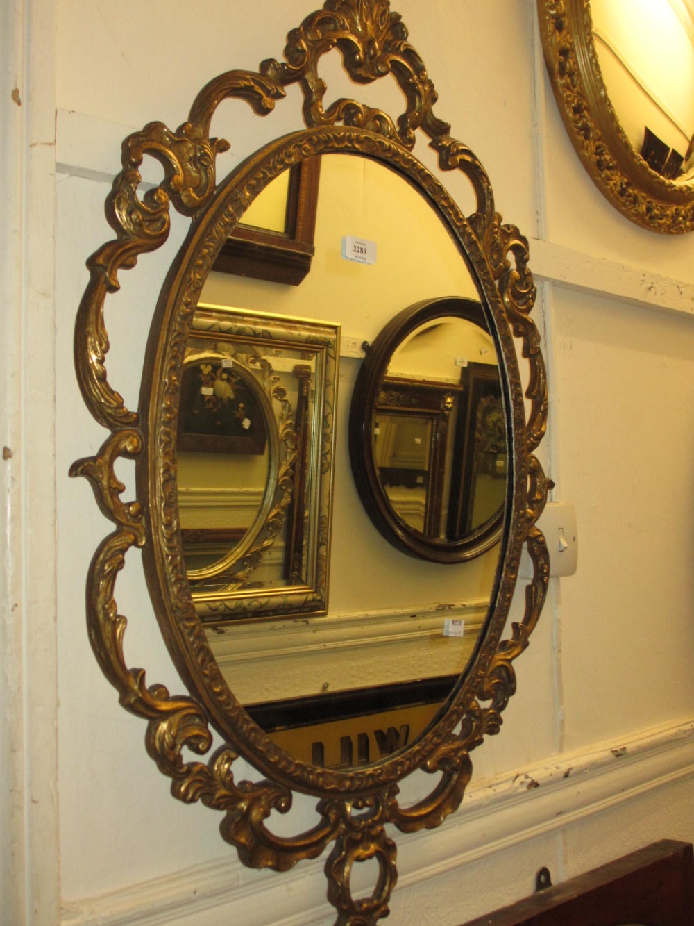 20th Century gilt framed oval wall mirror with C scroll pierced frame