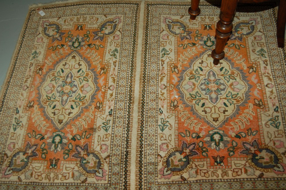 Indo Persian twin panel design rug with medallion and floral pattern on an orange and cream ground