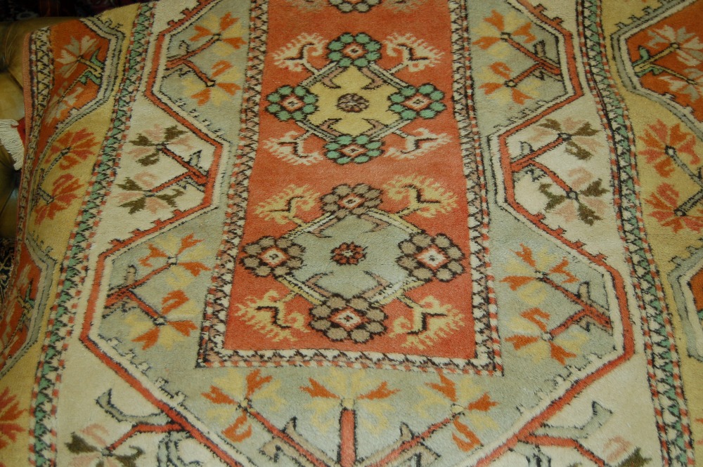 Modern Turkish rug with narrow band of medallions on a cream and terracotta ground with floral