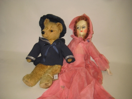 Articulated teddy bear in a sailors jacket and a 20th Century doll in pink dress
