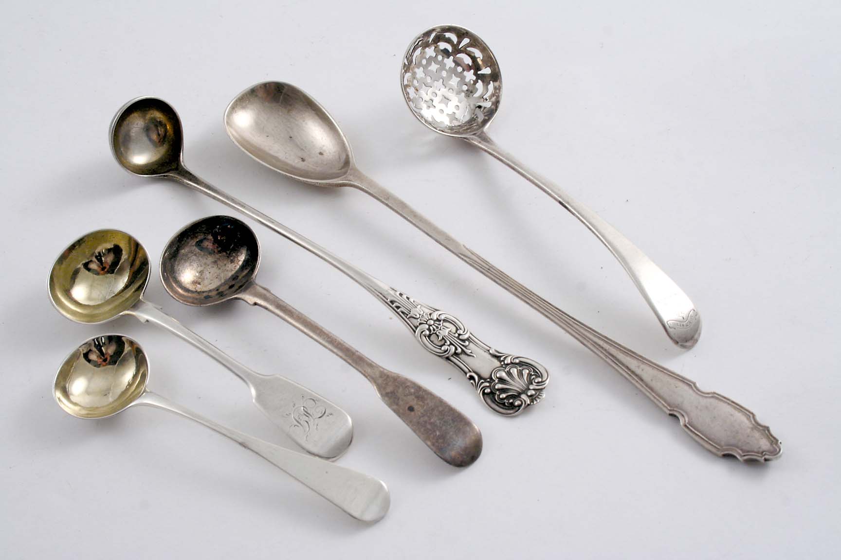 SIX ASSORTED SMALL SPOONS: Three George III / IV salt spoons, a modern cocktail stirring spoon, a