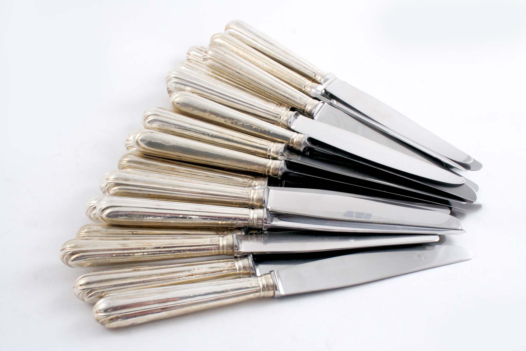 A SET OF TWENTY FOUR GEORGE III TABLE KNIVES with reeded handles & shaped terminals, crested, by