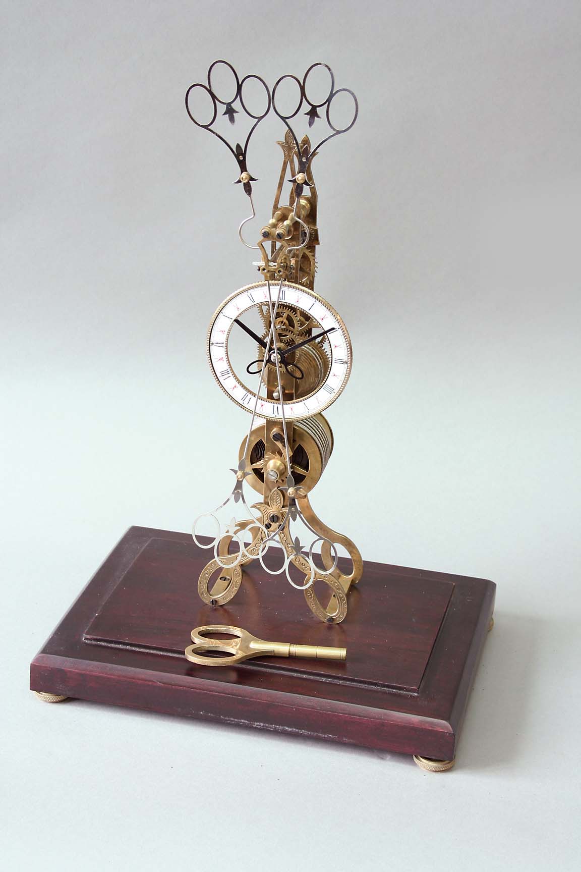 A SCISSORS SKELETON CLOCK dial white enamel, movement fusee, pendulum scissors - the scissor motif