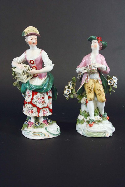 A PAIR OF DERBY FIGURES she with a birdcage, he with a nest of fledgings, 9ins. (23cms.)