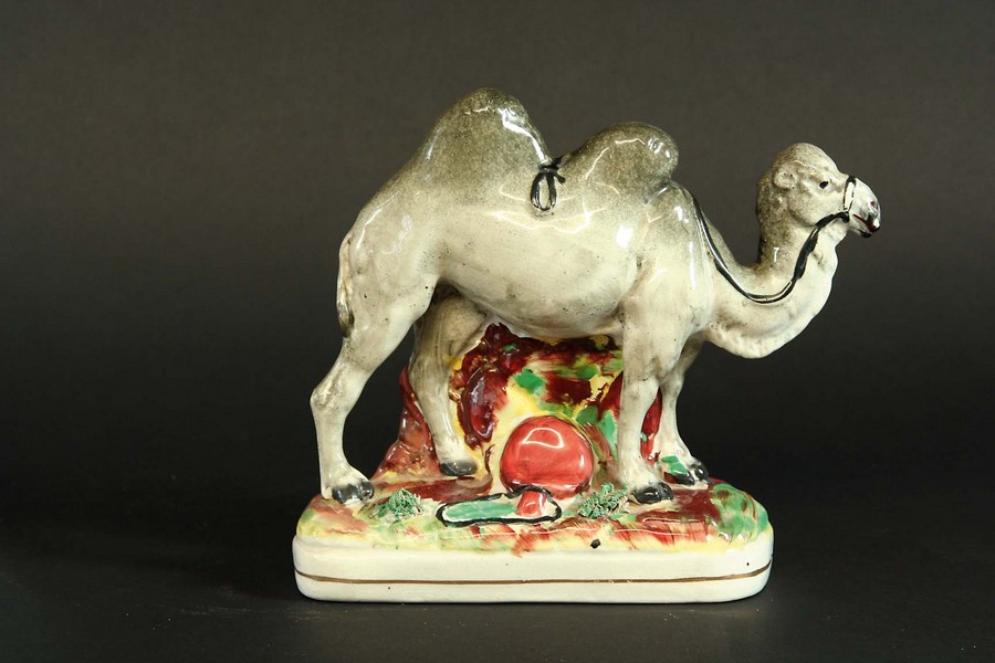 A STAFFORDSHIRE FIGURE OF A CAMEL 6 1/4ins. (16cms.) highCondition reports are available via the ‘