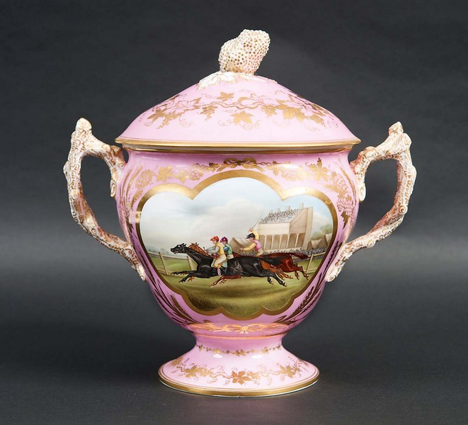 A COALBROOKDALE TWO HANDLED CUP AND COVER painted with a horse racing scene, reserved on a gilt