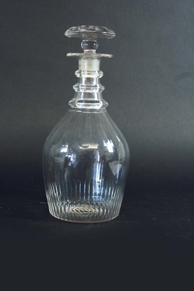 A SET OF THREE DECANTERS AND STOPPERS each with broad slice cut shoulders and fluted lower