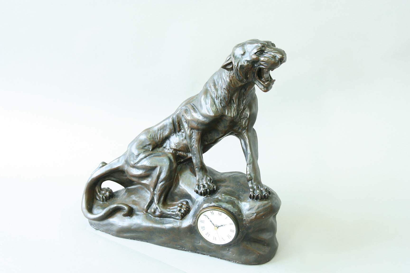 A RESIN BRONZE MANTEL CLOCK modelled as a roaring panther on a rocky outcrop, movement quartz, 16