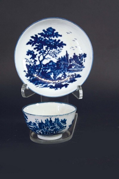 A FIRST PERIOD WORCESTER BLUE AND WHITE TEABOWL AND SAUCER printed with a landscape patternCondition
