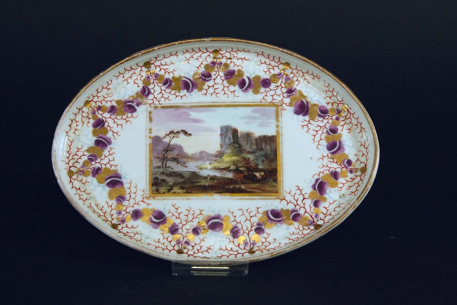 A PINXTON TEAPOT STAND painted with a central river landscape within purple and gilt swags, 6 1/