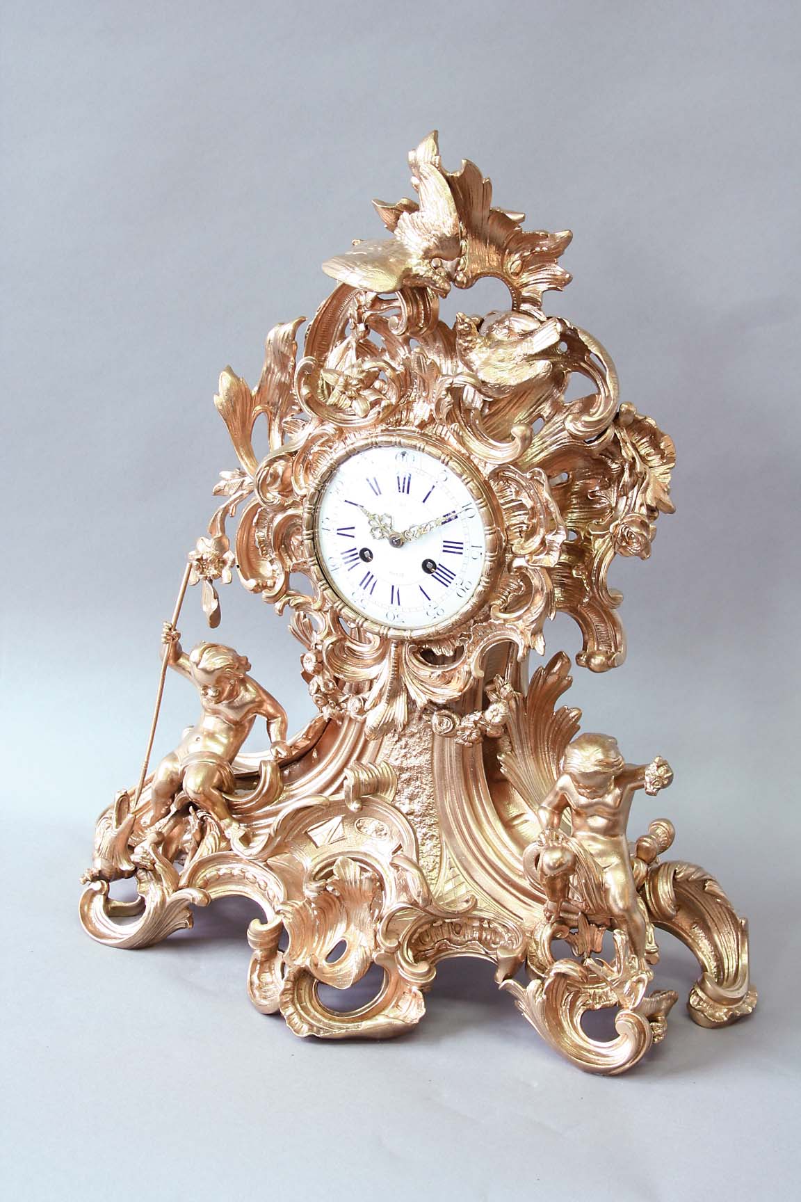 A GILT LACQUERED GILT BRONZE NEO ROCOCO MANTEL CLOCK dial white enamel with blue hour numerals,