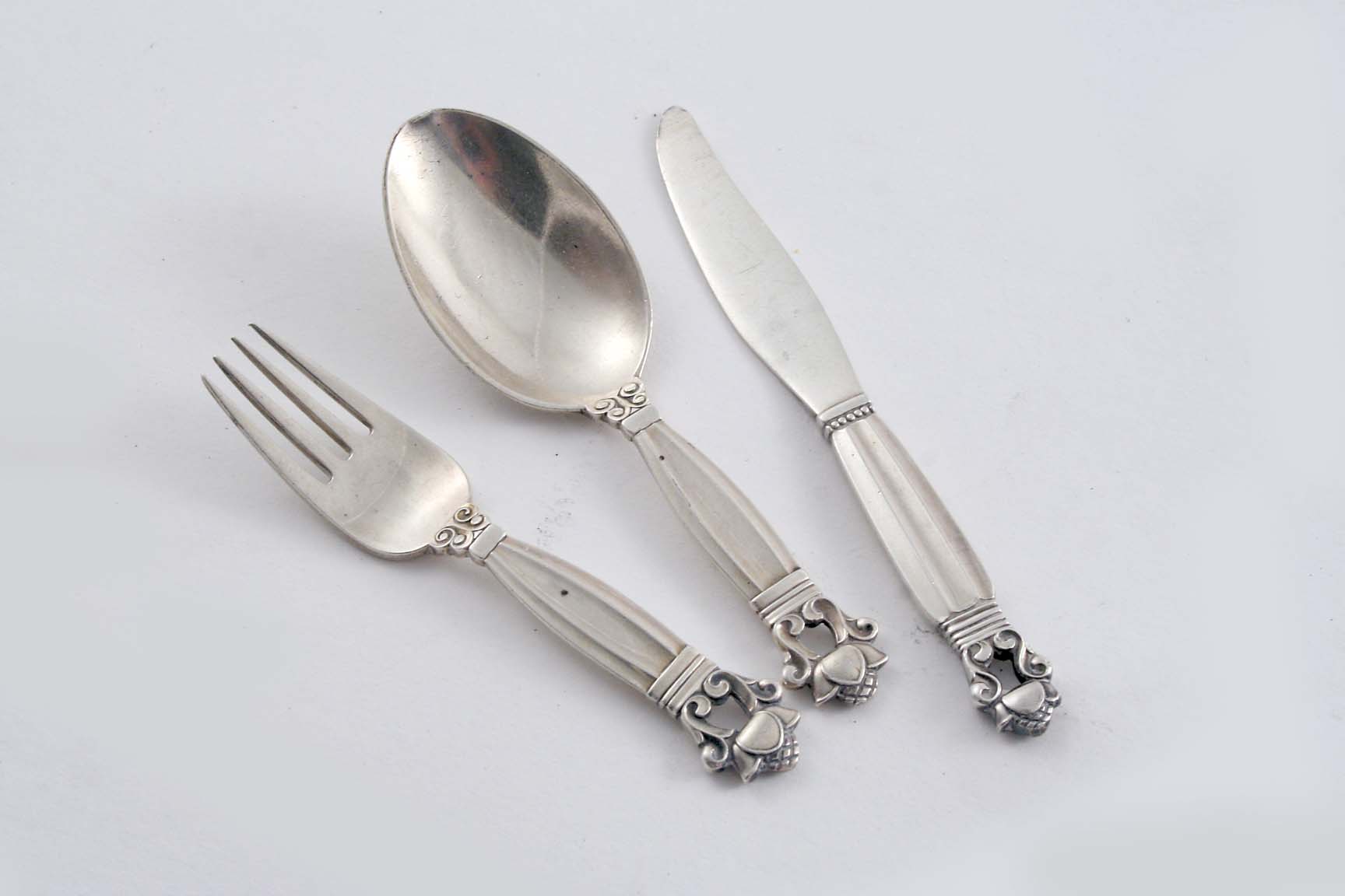 BY GEORG JENSEN: A modern Danish child`s knife, fork & spoon, Acorn pattern, with English import