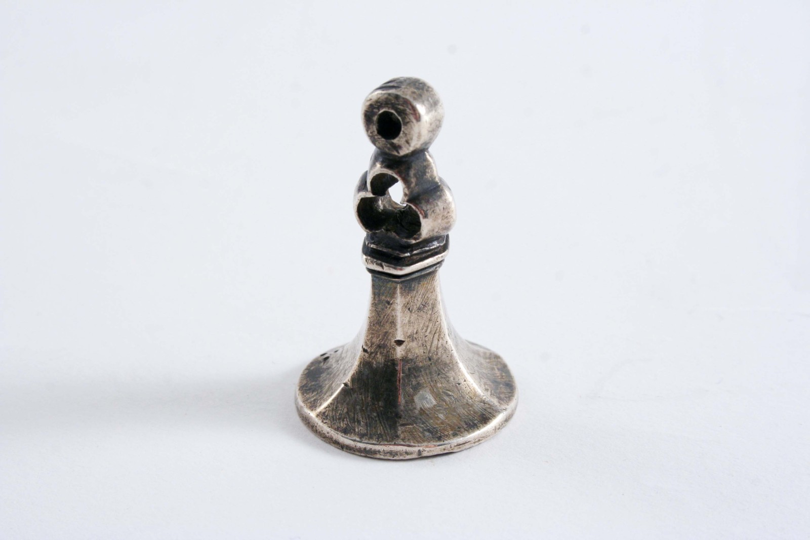 AN ANTIQUE FOB SEAL  with a faceted, flared body & a pierced trefoil & eye top section, the matrix