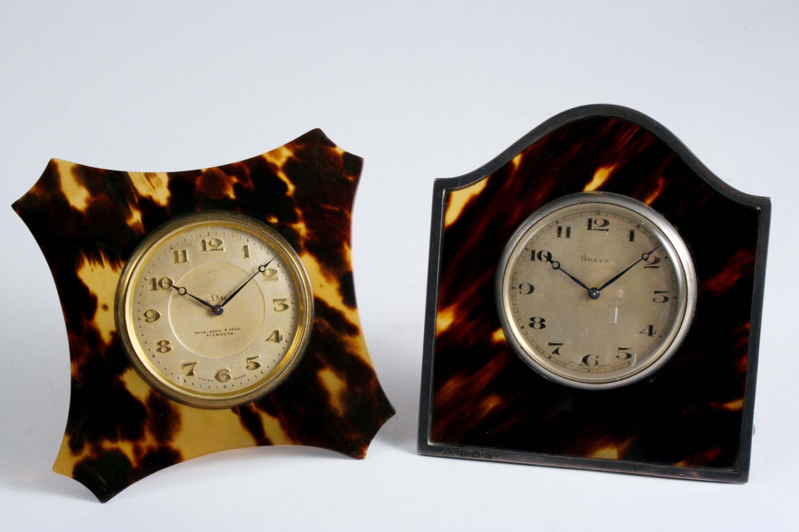 TWO DRESSING TABLE CLOCKS with tortoiseshell surrounds, one with silver mounts hallmarked Birmingham