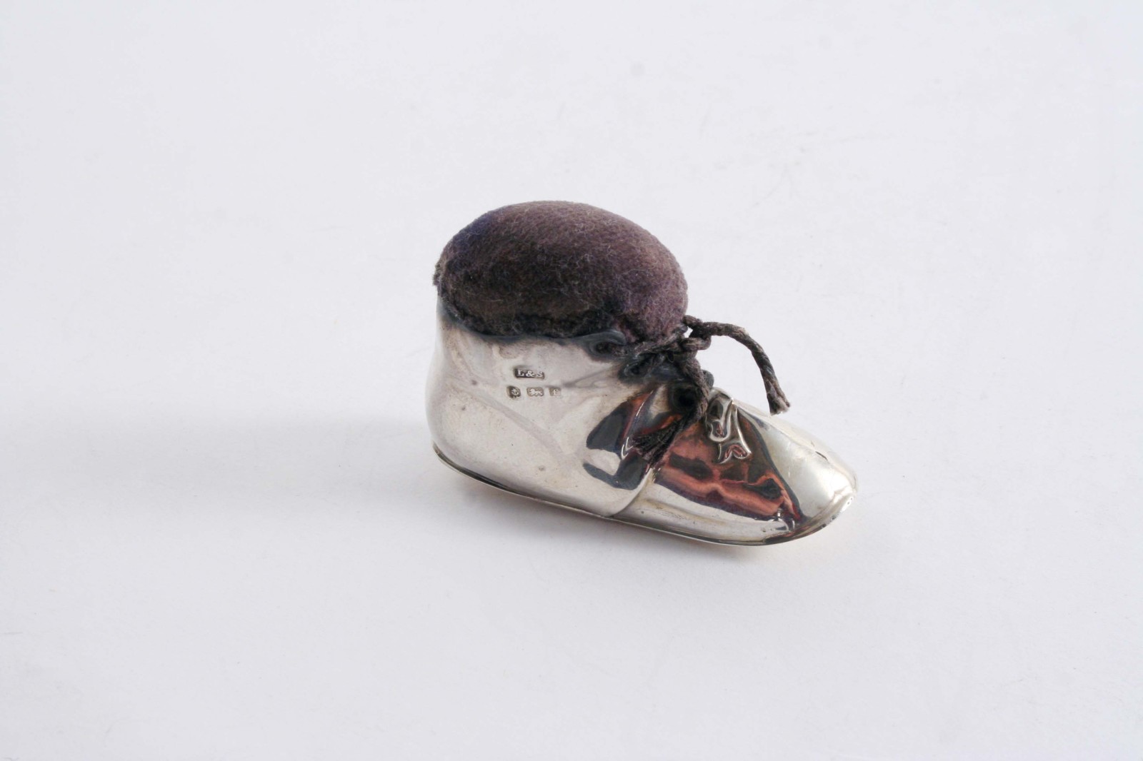AN EDWARDIAN NOVELTY PIN CUSHION in the form of a baby`s shoe, by Levi & Salaman, Birmingham