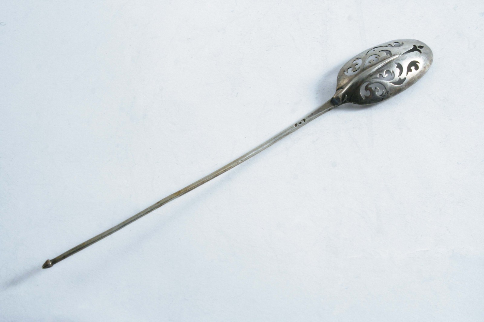 A GEORGE I MOTE SPOON with a long stem, & a plain rattail, the bowl pierced with scrolls, maker`s