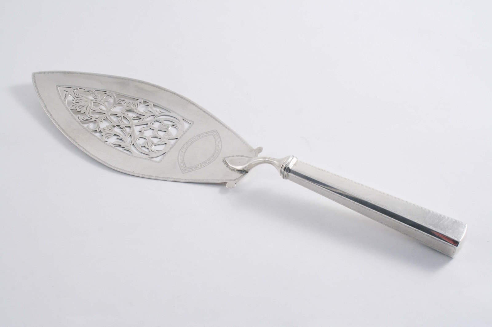 A GEORGE III PROVINCIAL FISH SLICE with a loaded, tapering handle, a pierced blade & border