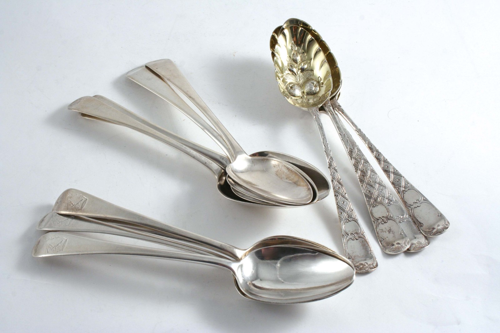 NINE VARIOUS GEORGE III OLD ENGLISH DESSERT SPOONS some crested, and four others with "berry"