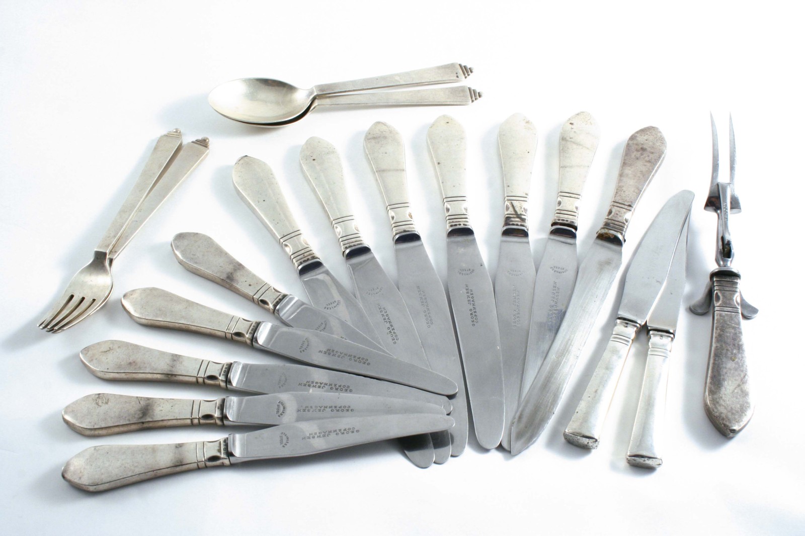 BY GEORG JENSEN: A set of seven Continental pattern table knives, five side knives & a carving