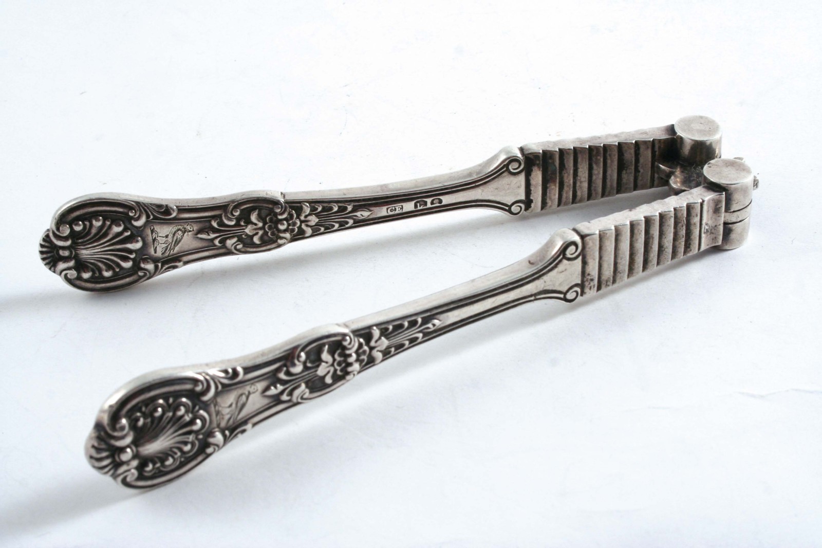 A PAIR OF GEORGE IV QUEEN `S PATTERN NUT CRACKS crested, by Charles Eley, London 1825;  5.9"  (14.
