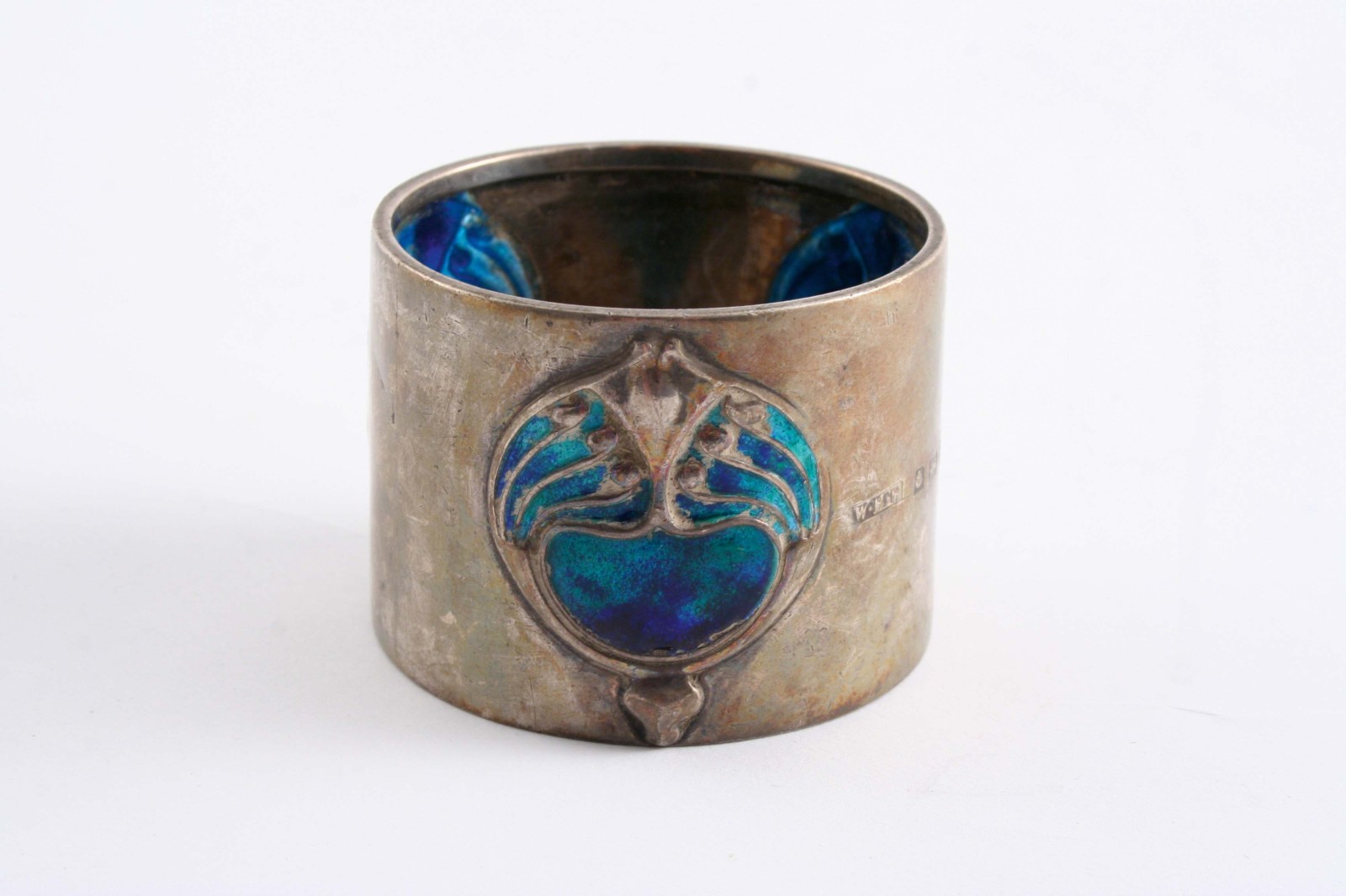 AN EDWARDIAN ART NOUVEAU NAPKIN RING decorated with three blue/turquoise enamelled motifs, by H.W.