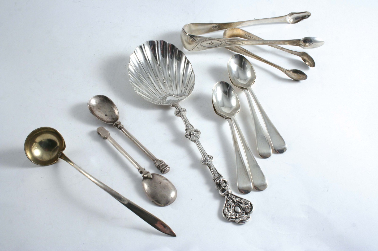 A MIXED LOT: A set of four modern egg spoons, an American cream ladle, two pairs of sugar tongs, a