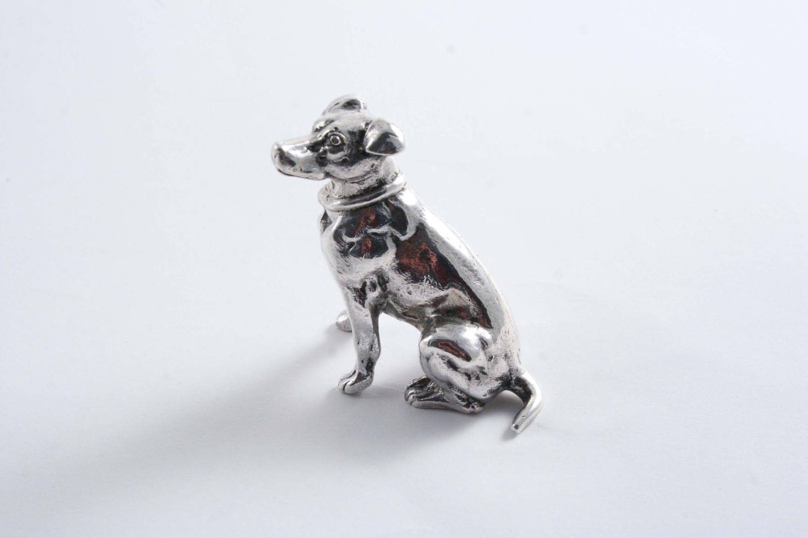 A CONTINENTAL MINIATURE CAST MODEL OF A JACK RUSSELL TERRIER with English import marks for London