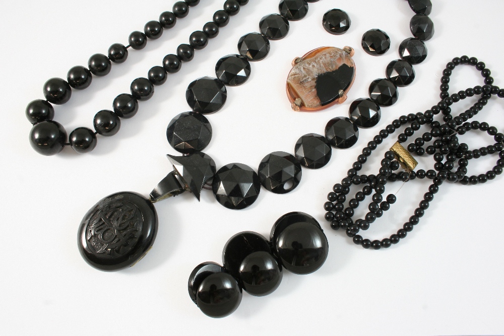 A QUANTITY OF JET JEWELLERY including a large locket pendant, a graduated bead necklace, and various