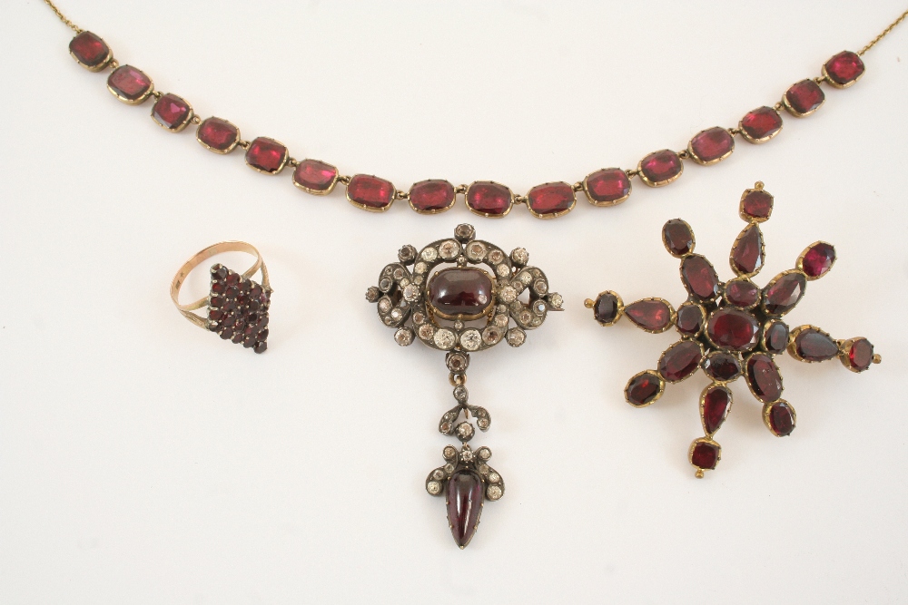 A GEORGIAN GARNET STAR BROOCH formed with oval and pear-shaped garnets in gold, 6cm. wide,
