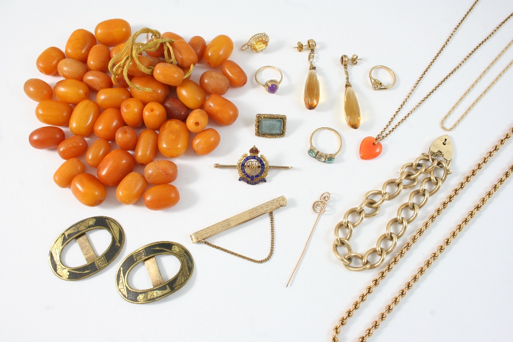 A QUANTITY OF JEWELLERY including various loose amber beads, a 15ct. gold and enamel brooch for