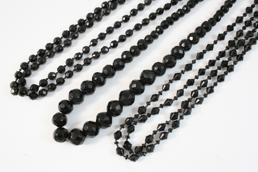 A SINGLE ROW GRADUATED JET BEAD NECKLACE formed with faceted jet beads, 68cm. long, together with